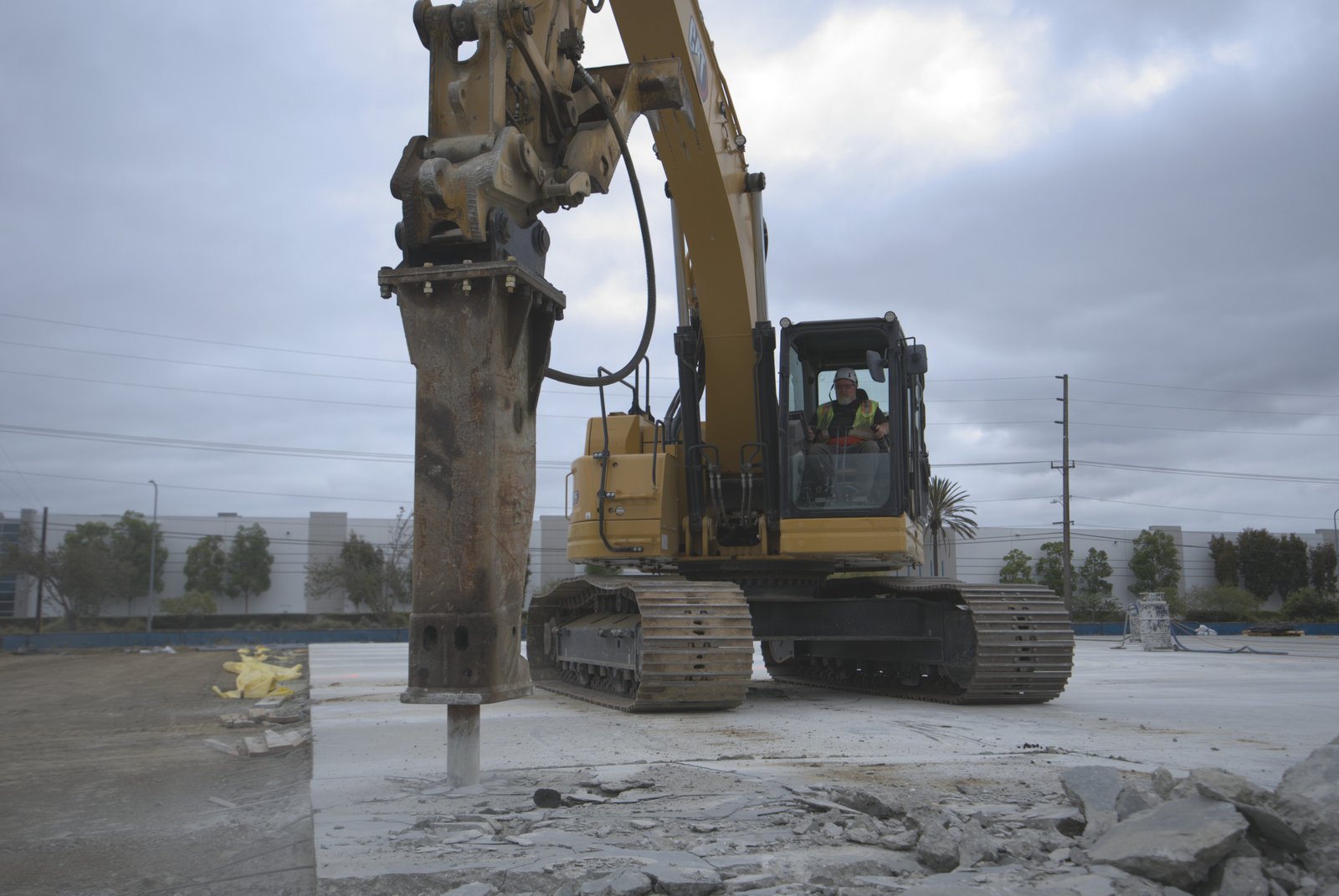 CAT excavator with hydraulic breaker demolishing concrete