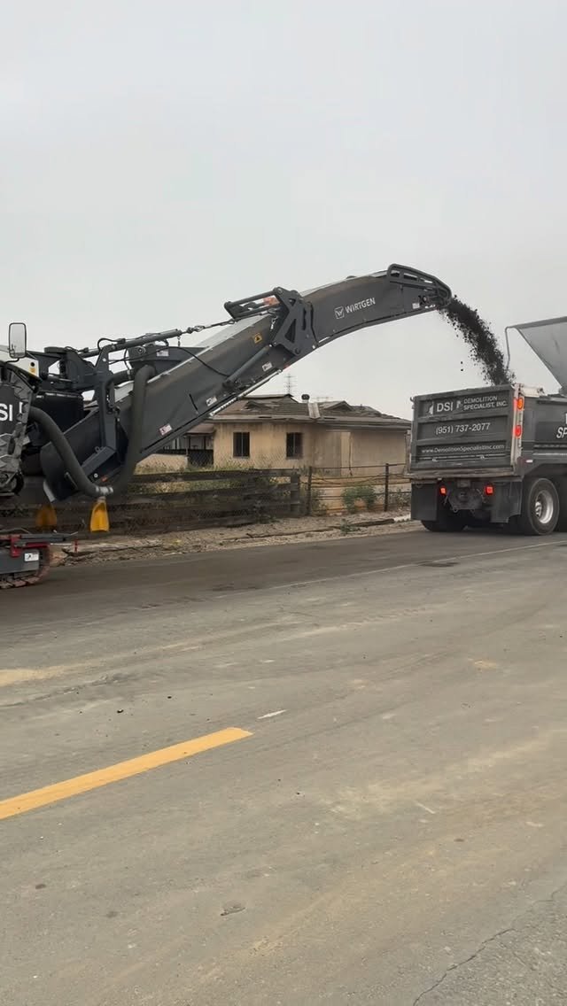 Asphalt milling machine removing pavement surface layer